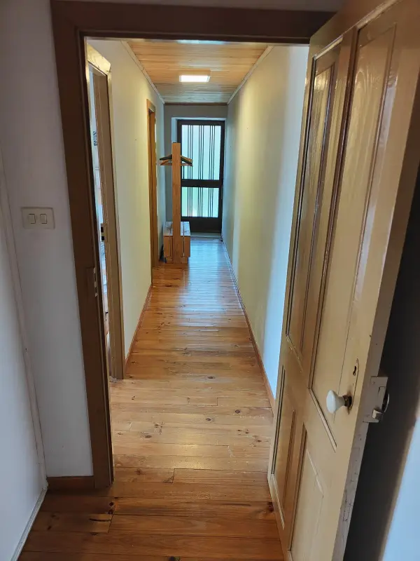 Pasillo interior con suelo de madera de la casa rural