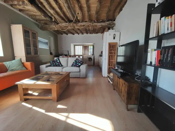 Salón con vigas de madera vista en Casa Elena